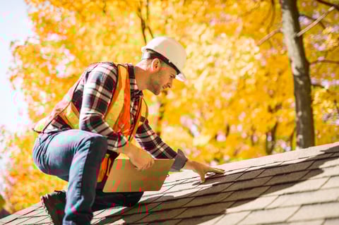 Professional roofer inspecting roof and chimney